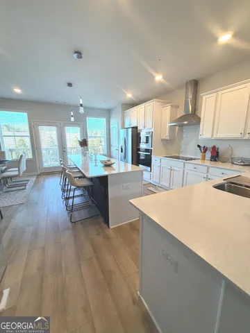 a living room with stainless steel appliances kitchen island granite countertop furniture and a wooden cabinets