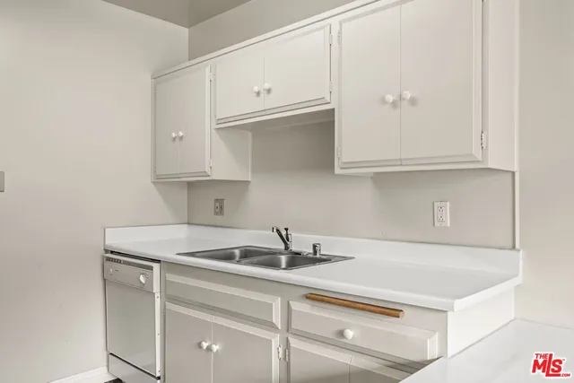 a kitchen with a sink cabinets and appliances