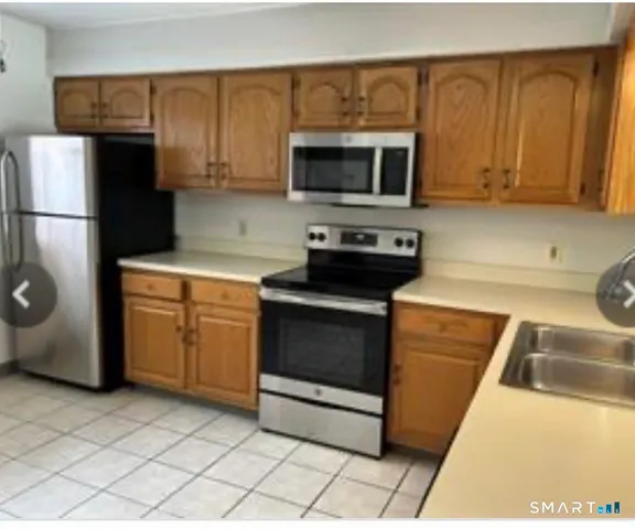 a kitchen with stainless steel appliances granite countertop a stove microwave and refrigerator