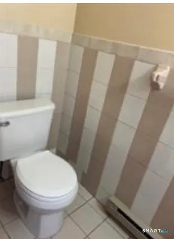 a white toilet sitting next to a shower