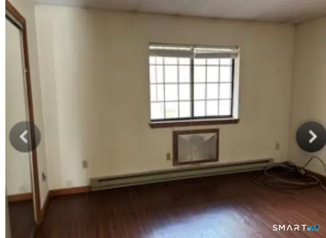 a room with a wooden floor and a window