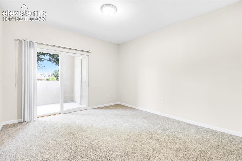 3864 Riviera Grove, Unit 102 Colorado Springs, CO 80922 - Photo 17 of 24 Spacious room featuring neutral carpeting and light-toned walls