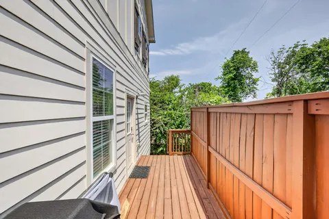 a view of a house with a yard plants and large tree