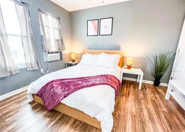 a bedroom with a bed and wooden floor