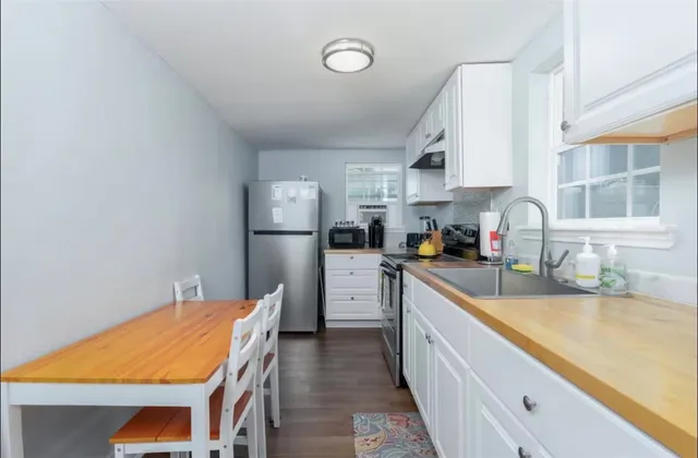 a kitchen with refrigerator cabinets and wooden floor