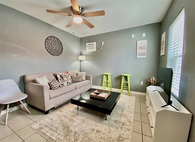 a living room with furniture a clock on wall and a window