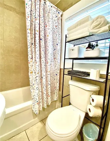 a white toilet sitting next to a bath tub