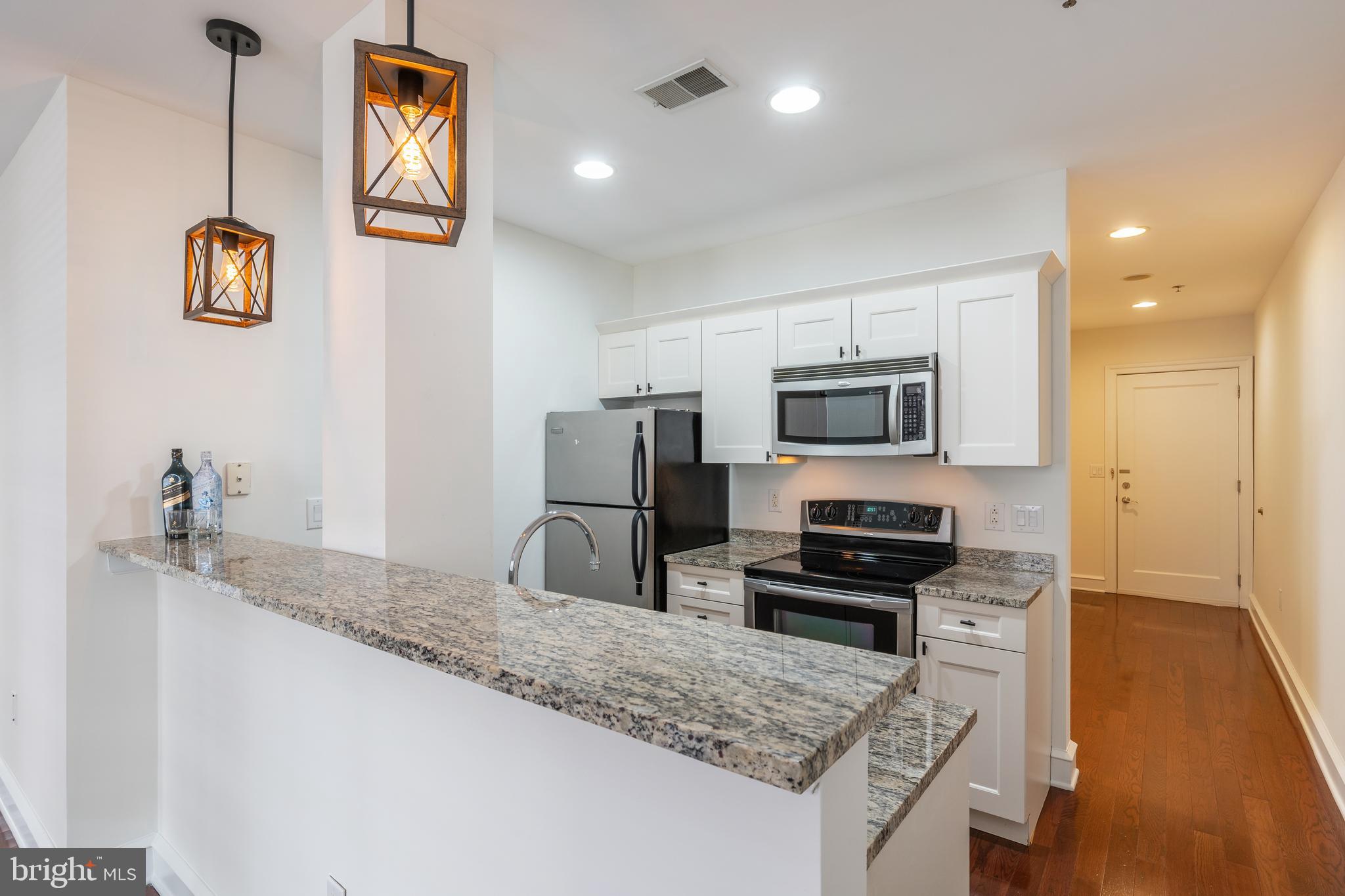 a kitchen with granite countertop a sink and stainless steel appliances