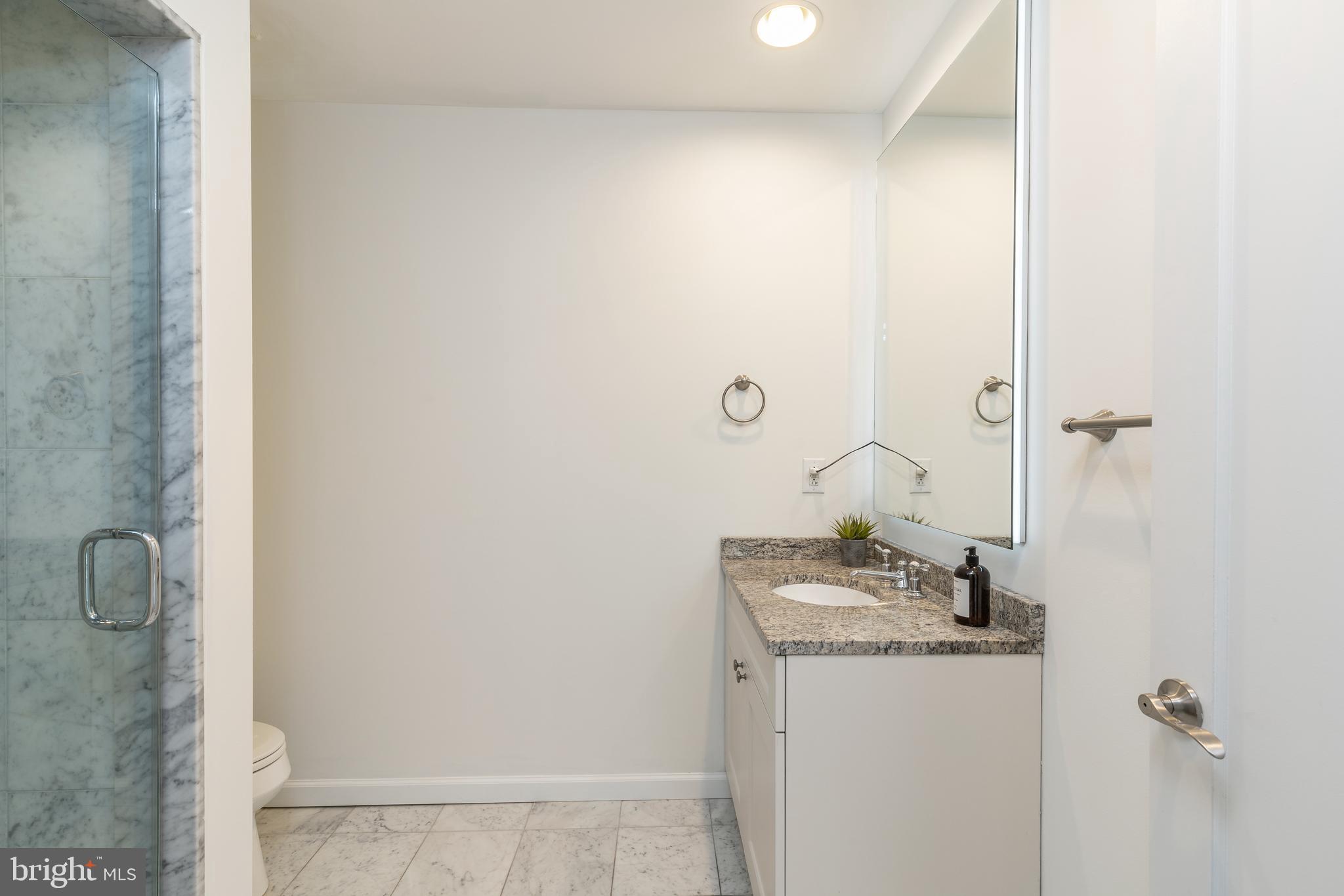 1811 Chestnut Street, Unit 707 Philadelphia, PA 19103 - Photo 12 of 39 a bathroom with a granite countertop sink