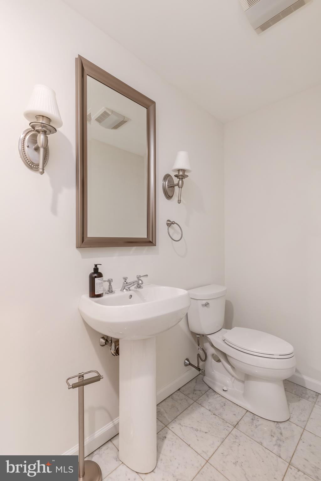1811 Chestnut Street, Unit 707 Philadelphia, PA 19103 - Photo 3 of 39 a bathroom with a toilet sink and mirror