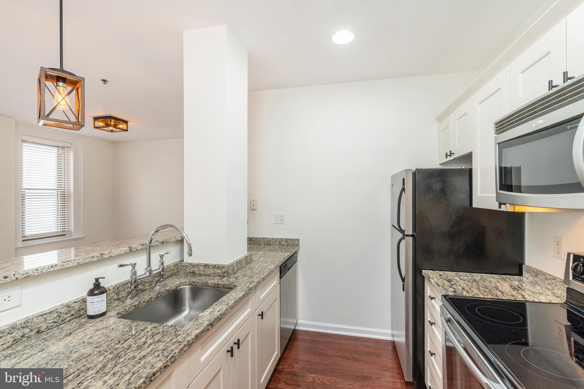 1811 Chestnut Street, Unit 707 Philadelphia, PA 19103 - Photo 6 of 39 a kitchen with stainless steel appliances granite countertop a sink stove and refrigerator