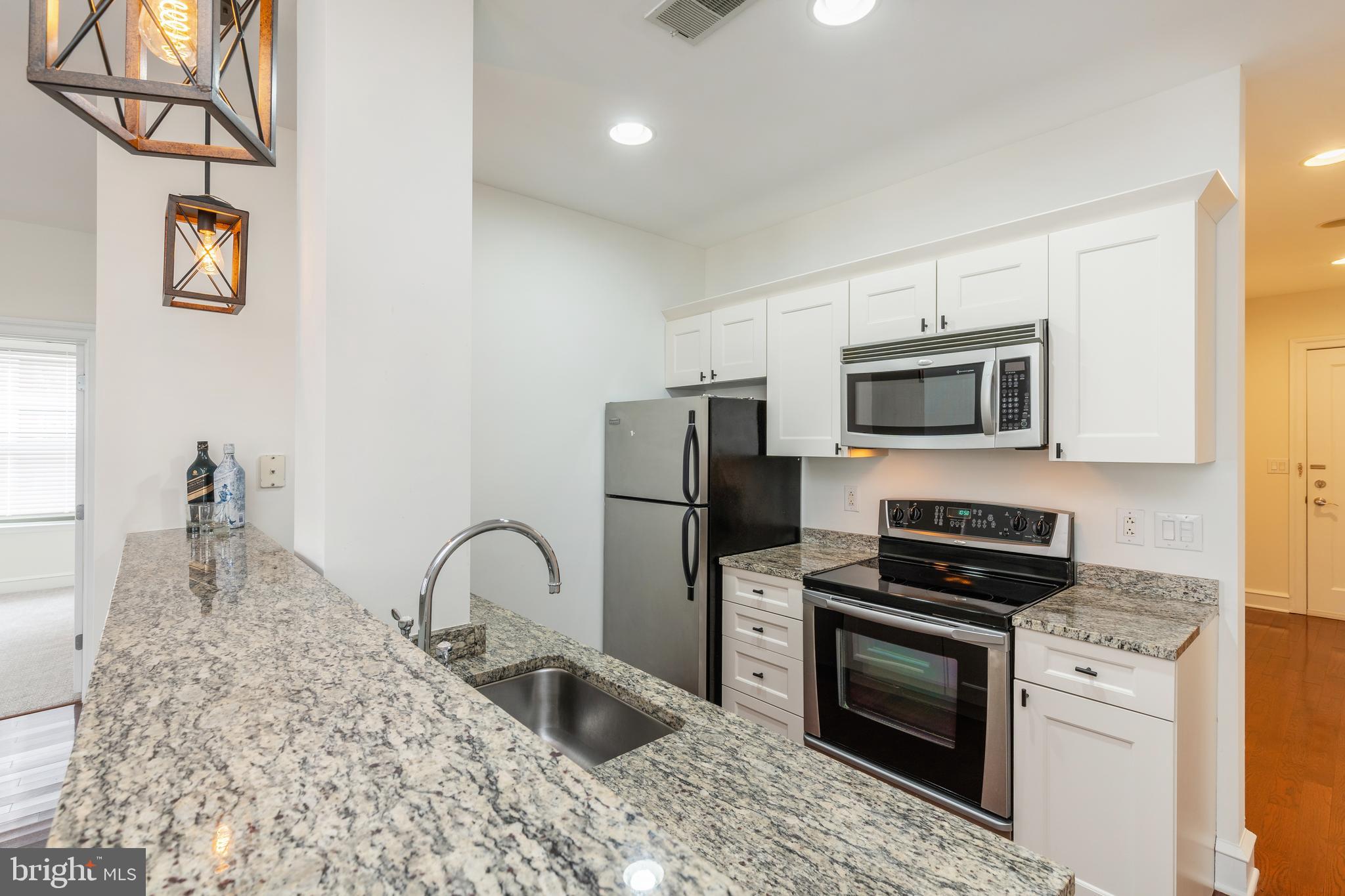 1811 Chestnut Street, Unit 707 Philadelphia, PA 19103 - Photo 7 of 39 a kitchen with stainless steel appliances granite countertop a stove a sink and a microwave