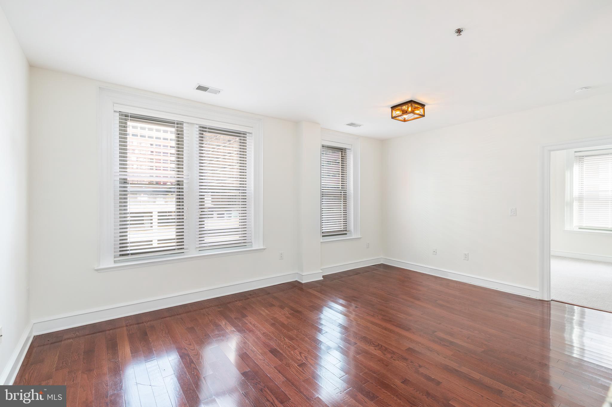 1811 Chestnut Street, Unit 707 Philadelphia, PA 19103 - Photo 9 of 39 an empty room with a window and wooden floor