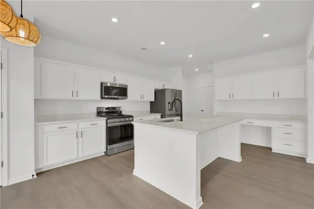 a kitchen with white cabinets and stainless steel appliances