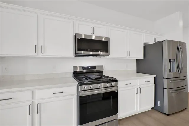 a kitchen with cabinets stainless steel appliances and a counter space