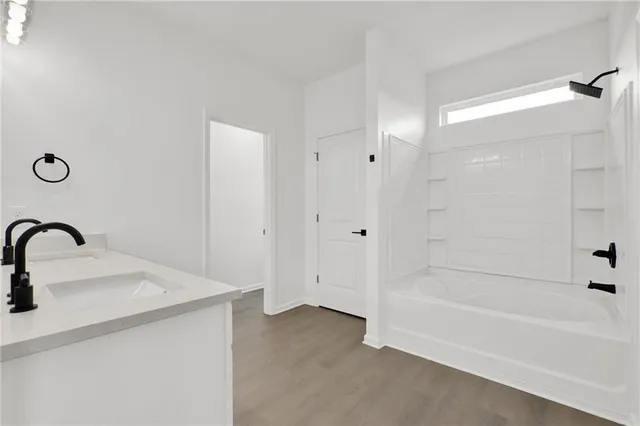 a spacious bathroom with a double vanity sink a mirror and shower
