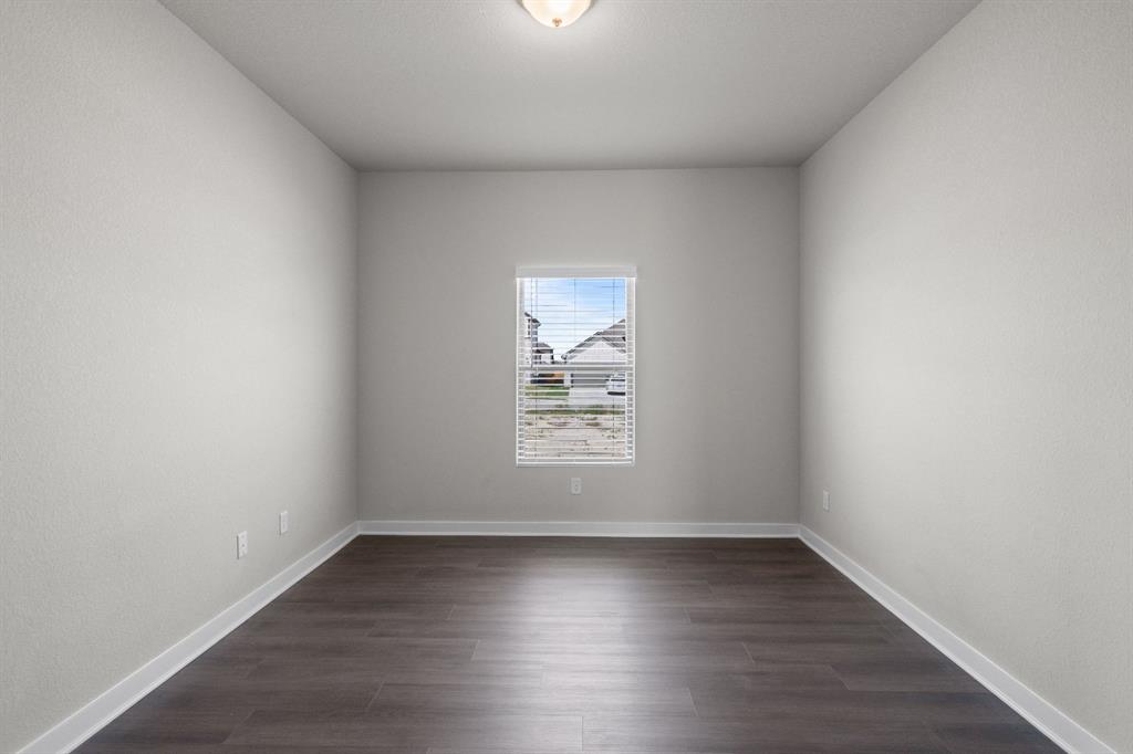 177 Sleep Hollow Jarrell, TX 76537 - Photo 19 of 24 Bright interior space featuring wood-finish flooring, white baseboards, and neutral wall tones