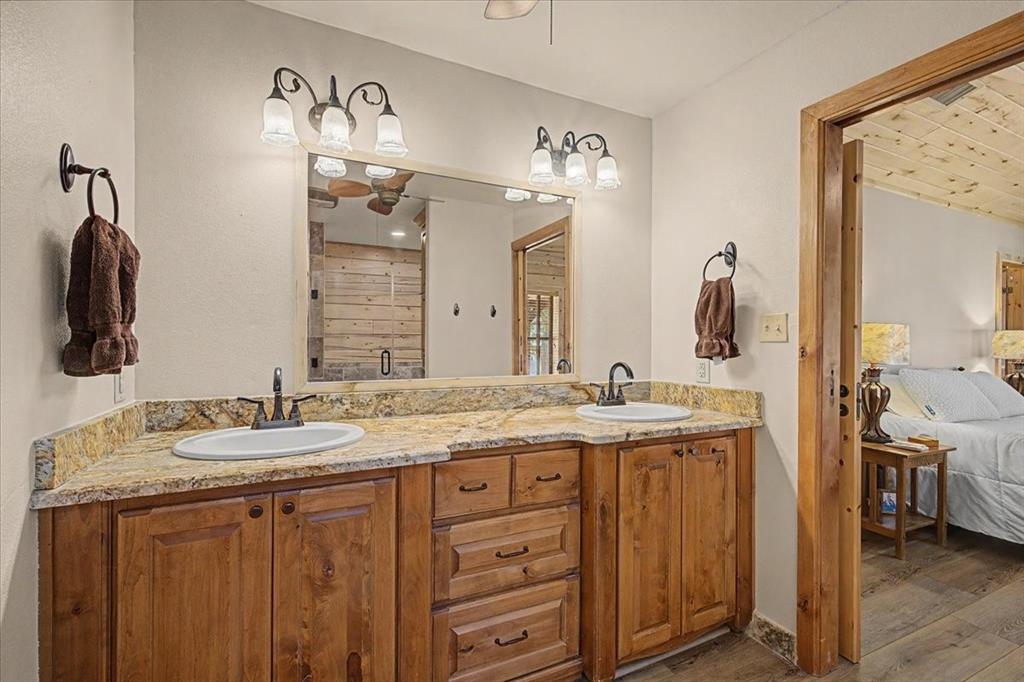 2789 Hanging Tree Road Bowie, TX 76230 - Photo 19 of 40 Double vanity with wood-finish cabinetry, light-toned countertop, and dual sinks