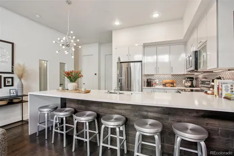 a kitchen with stainless steel appliances granite countertop a table chairs stove and microwave