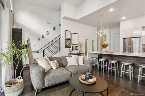 a living room with furniture kitchen view and a large window