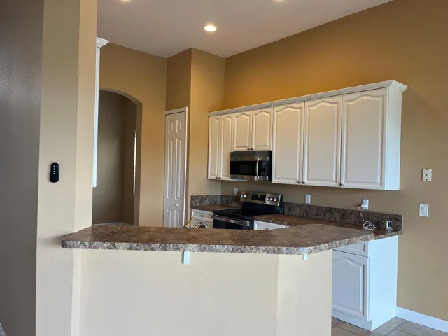 a view of kitchen with microwave and cabinets