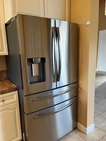 a metallic refrigerator freezer sitting in a kitchen