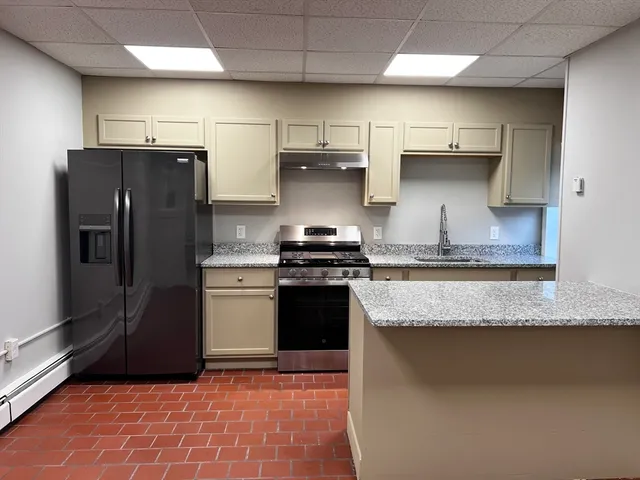a kitchen with granite countertop stainless steel appliances and a counter space