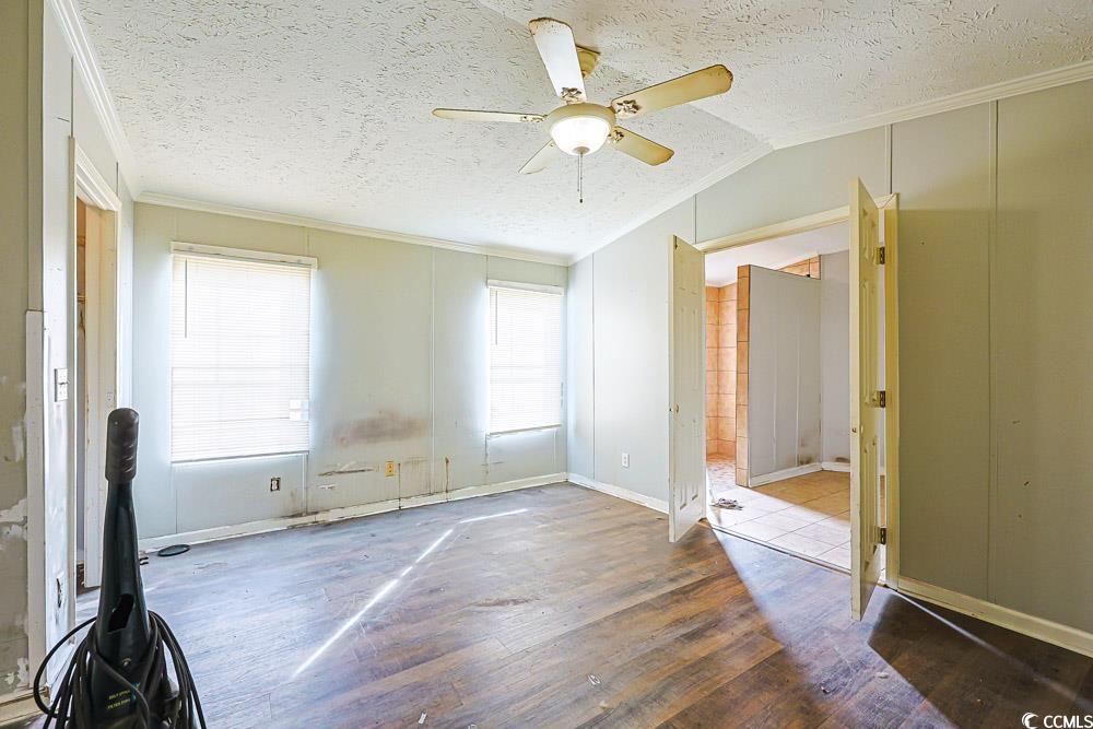 175 Darlene Drive Myrtle Beach, SC 29588 - Photo 13 of 31 Spare room with wood-type flooring, a textured ceiling, crown molding, a ceiling fan, and lofted ceiling