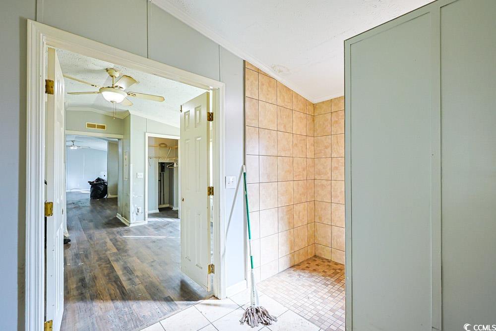 175 Darlene Drive Myrtle Beach, SC 29588 - Photo 15 of 31 Bathroom with ornamental molding, lofted ceiling, tile patterned flooring, a ceiling fan, and a tile shower