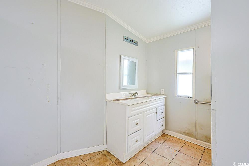 175 Darlene Drive Myrtle Beach, SC 29588 - Photo 16 of 31 Bathroom featuring vanity, crown molding, light tile patterned flooring, and lofted ceiling