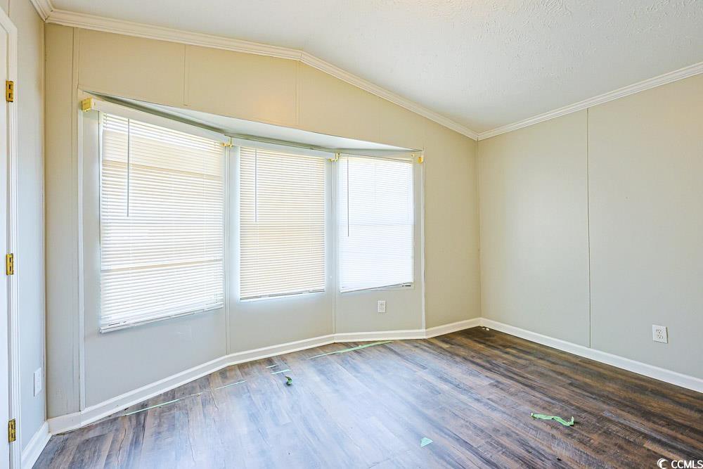 175 Darlene Drive Myrtle Beach, SC 29588 - Photo 17 of 31 Unfurnished room with crown molding, lofted ceiling, and dark wood-style floors