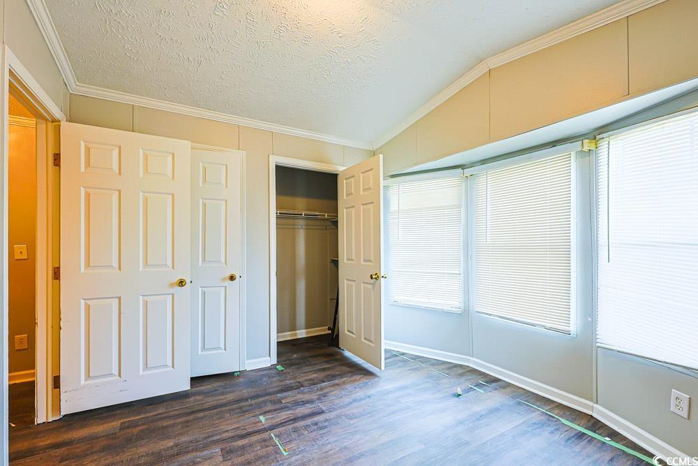 175 Darlene Drive Myrtle Beach, SC 29588 - Photo 19 of 31 Unfurnished bedroom with crown molding, a textured ceiling, dark wood finished floors, and a closet