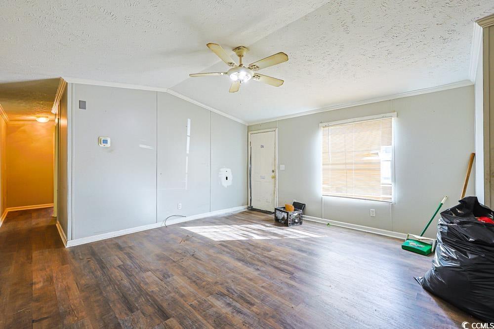 175 Darlene Drive Myrtle Beach, SC 29588 - Photo 4 of 31 Unfurnished living room with ornamental molding, wood finished floors, a textured ceiling, a ceiling fan, and lofted ceiling