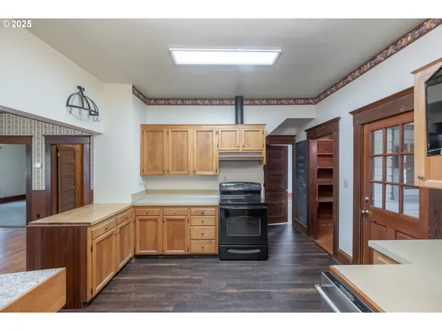 a kitchen with granite countertop a refrigerator and a stove top oven