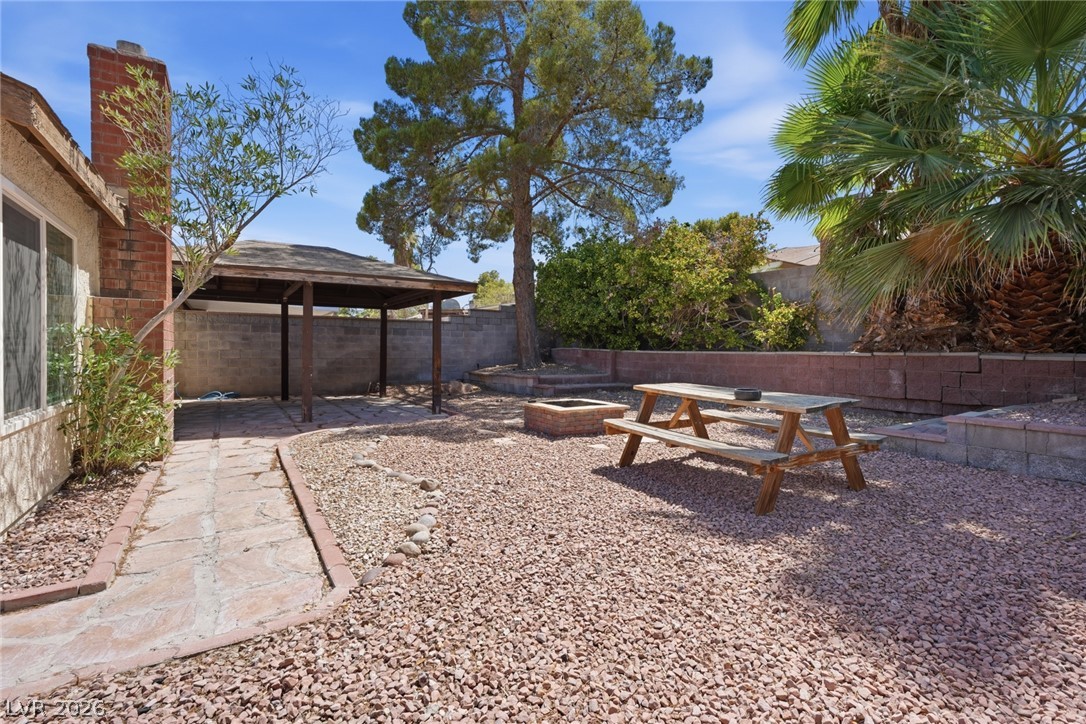 3971 Spring Leaf Drive Las Vegas, NV 89147 - Photo 41 of 48 A private backyard retreat featuring a covered patio, fire pit, and ample space for relaxation.