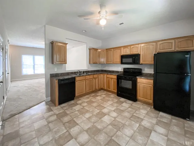 a kitchen with stainless steel appliances granite countertop a refrigerator a stove a sink a microwave and island