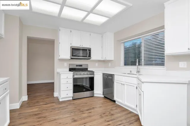 a kitchen with stainless steel appliances a stove sink microwave and cabinets