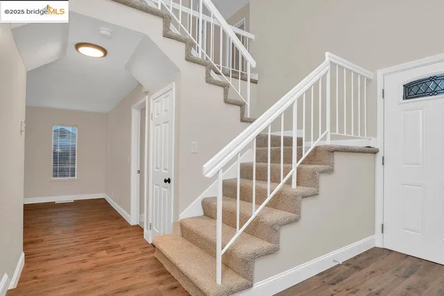a view of entryway and hall with wooden floor