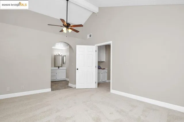 a view of a room with a ceiling fan and entryway