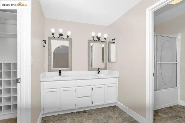 a bathroom with a double vanity sink a mirror and a shower