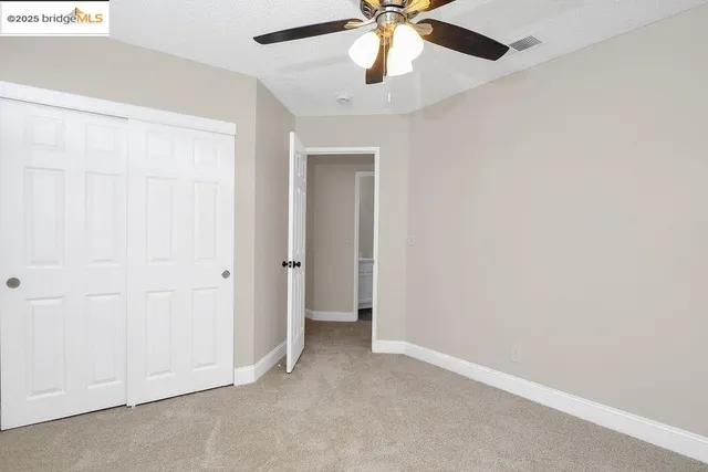 an empty room with a fan and a fan