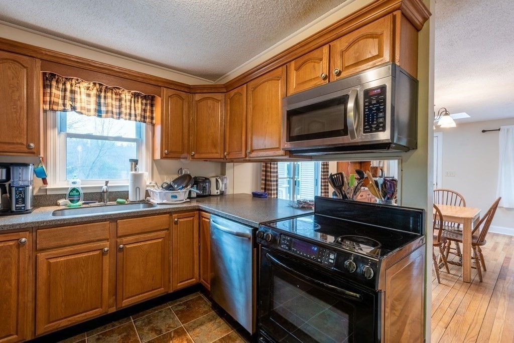 320 Pelham Road Amherst, MA 01002 - Photo 12 of 23 a kitchen with stainless steel appliances granite countertop a stove a sink and a microwave