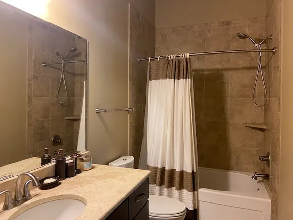 a bathroom with a granite countertop sink toilet and shower