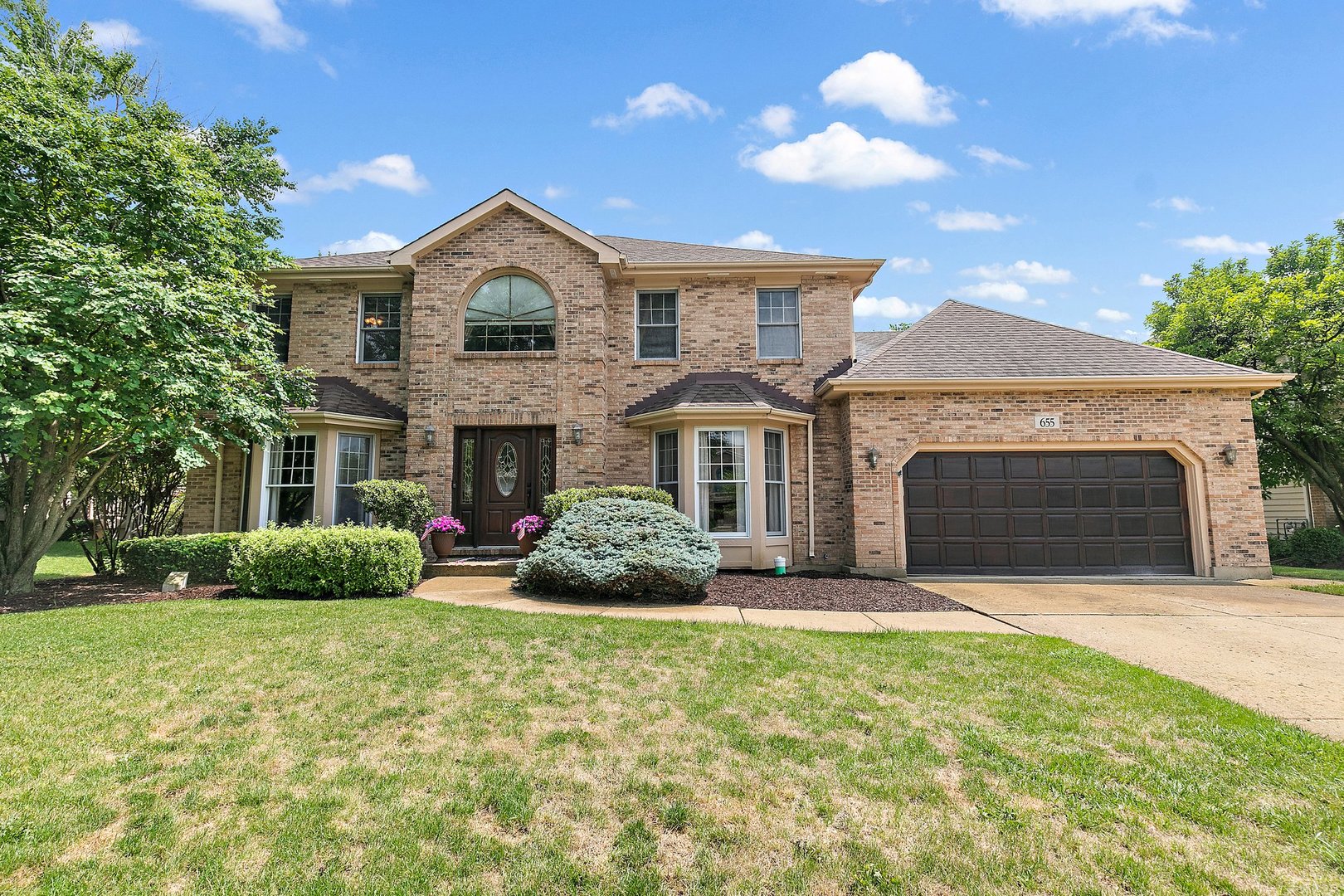 655 Red Maple Lane Roselle, IL 60172 - Photo 2 of 40 a front view of a house with a yard and garage