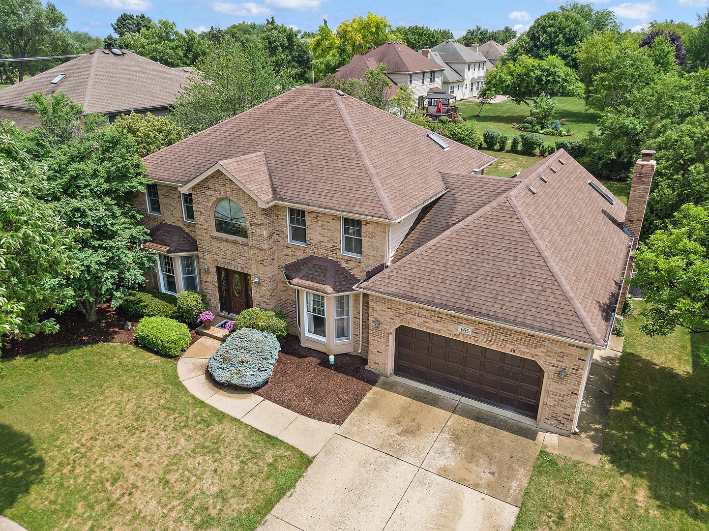 655 Red Maple Lane Roselle, IL 60172 - Photo 32 of 40 a view of a house with a yard and a fireplace