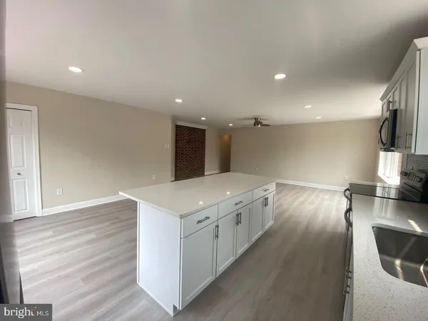 a kitchen with a sink and wooden floor