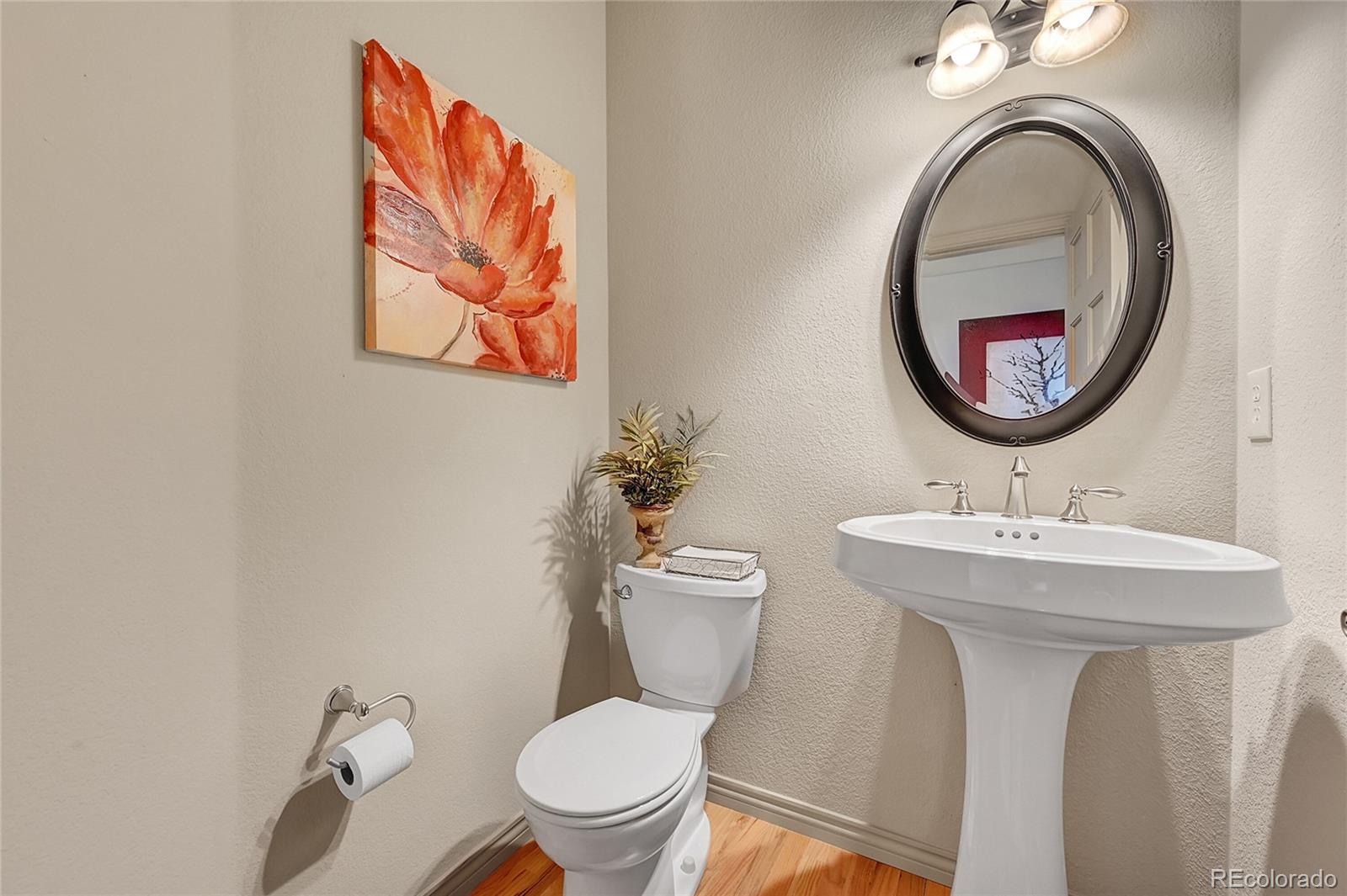 11232 West Cooper Drive Littleton, CO 80127 - Photo 19 of 48 a bathroom with a toilet a sink and a mirror