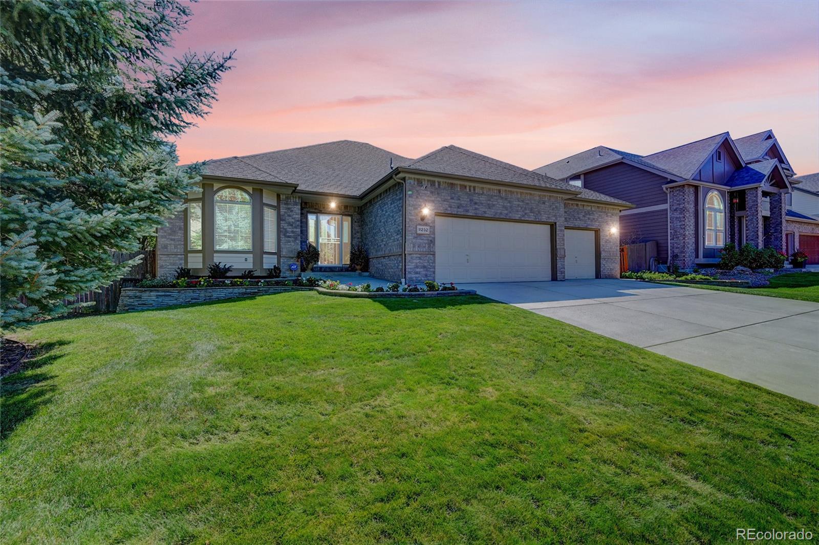 11232 West Cooper Drive Littleton, CO 80127 - Photo 2 of 48 a front view of a house with a yard and garage