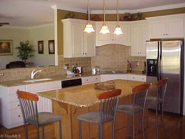5705 Cape Fox Drive Oak Ridge, NC 27310 - Photo 6 of 8 Other. Kitchen with granite counterops, pendant lighting over bar, smooth top stove, white sink.
