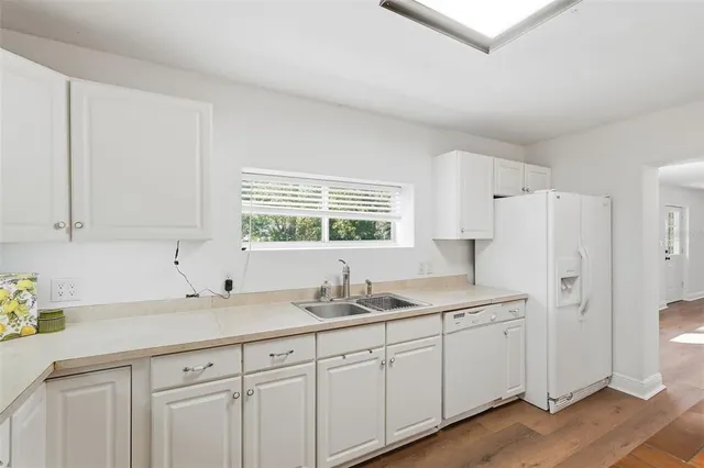 a kitchen with white cabinets and white appliances